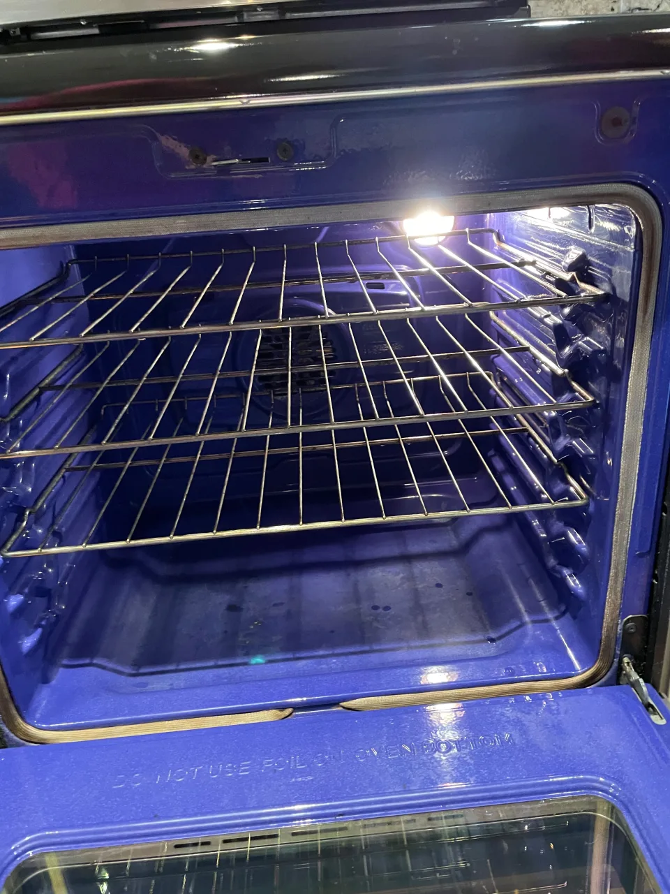 Interior de horno azul completamente limpio y brillante tras una limpieza post construcción