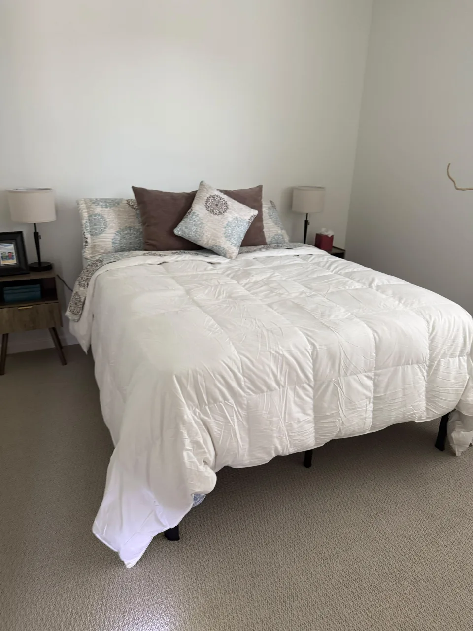 Dormitorio limpio con cama tendida en blanco, mesas de noche y lámparas, ambiente ordenado tras limpieza residencial